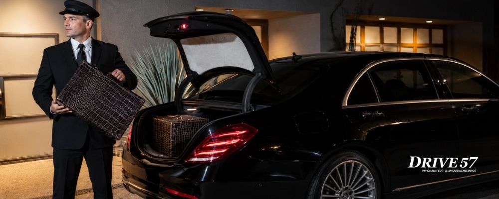 Professioneller Chauffeur verlädt Gepäck in eine schwarze Mercedes S-Klasse für einen VIP-Transfer
