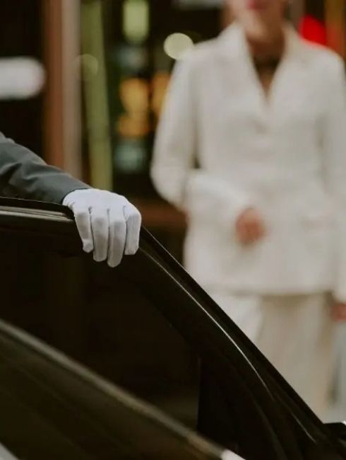 Chauffeur öffnet die Limousinentür für einen diskreten VIP Flughafentransfer in Berlin