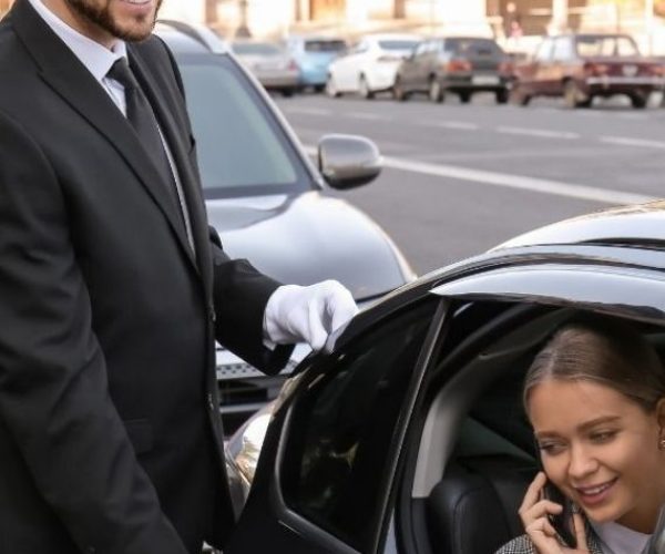 Business Chauffeur Service in Berlin – professioneller Chauffeur öffnet einer Geschäftskundin die Tür zur Limousine
