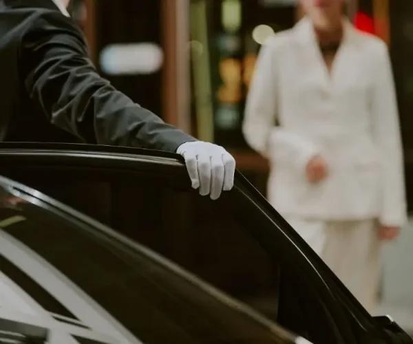 Professioneller Chauffeur öffnet die Tür einer Luxuslimousine von Drive 57 in Berlin